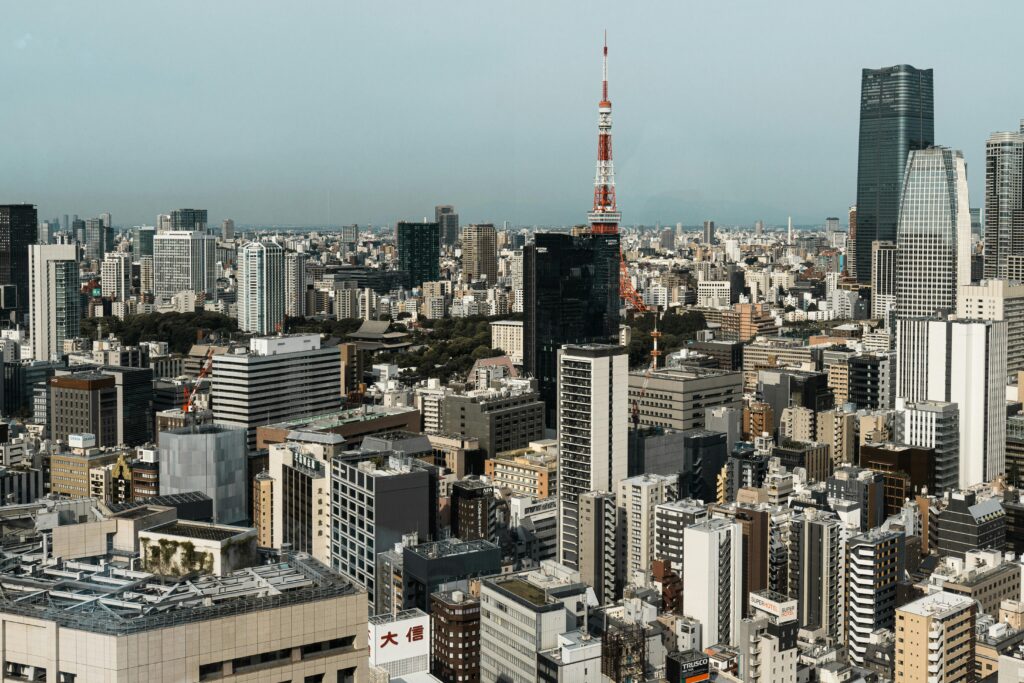 Dense Tokyo skyline with Tokyo Tower rising among high‑rise buildings.