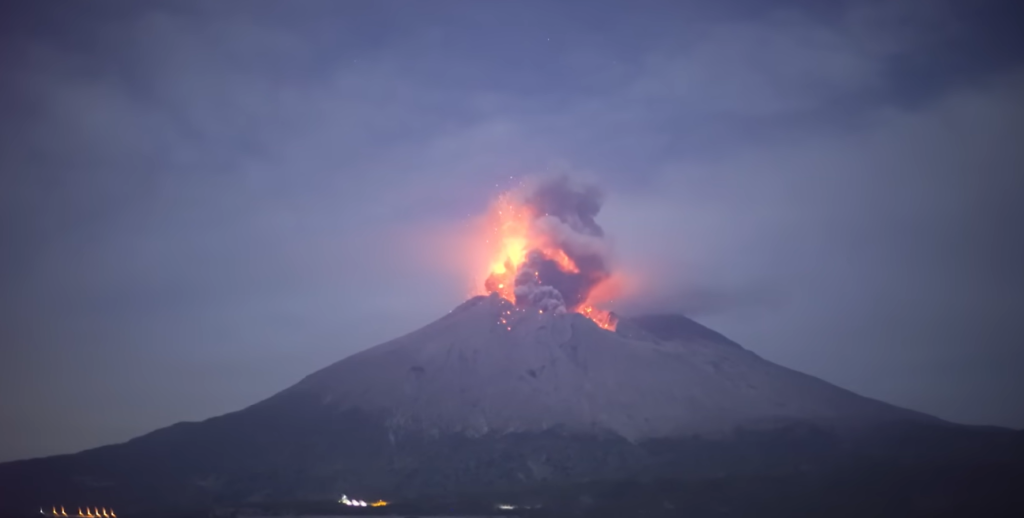 Mount Asama erupting with a tall ash plume rising above the summit.