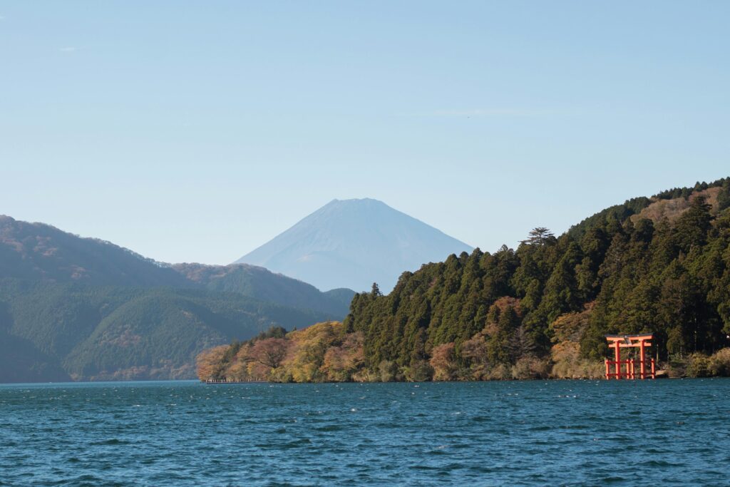 view of lake ashi framed through a ryokan window, mountains encircling the water