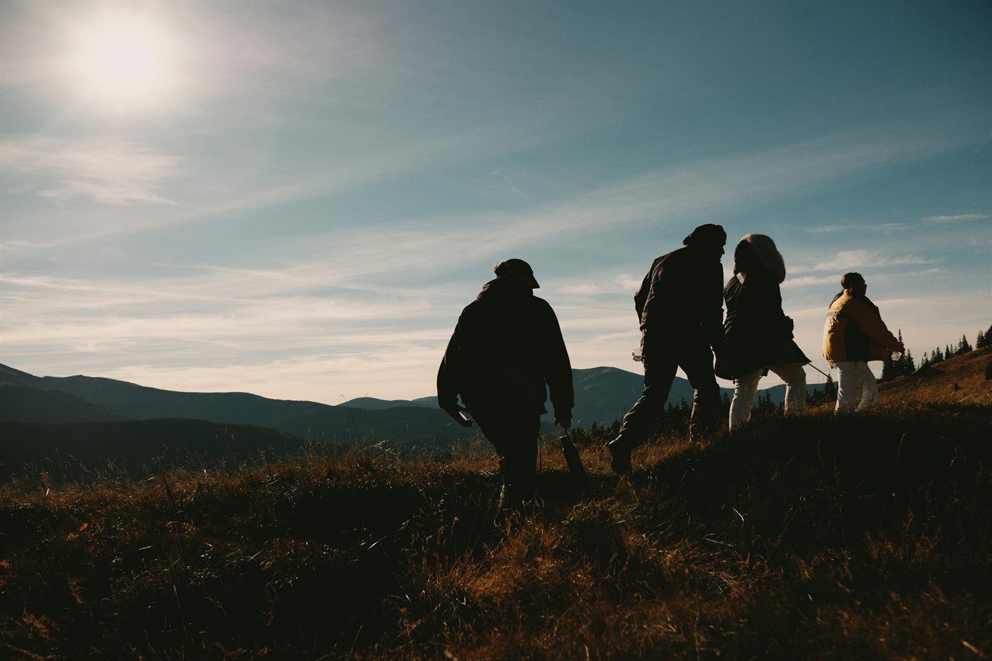 Family hiking together on a mountain trail, multi-generational outdoor educational experience