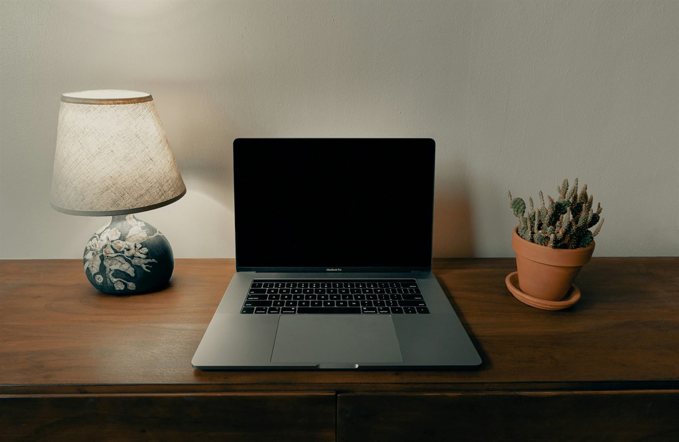 Open laptop computer on a brown wooden desk, soft natural light, focused research environment