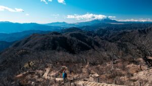 Small group walking on a dirt road through Japanese countryside with mountains in the background