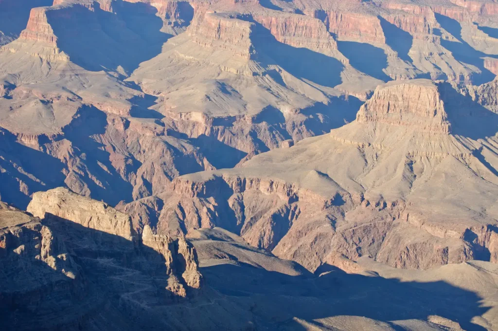 Grand Canyon South Rim at dusk, with layered red rock walls dropping toward the Colorado River far below