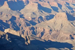 Grand Canyon South Rim at dusk, with layered red rock walls dropping toward the Colorado River far below