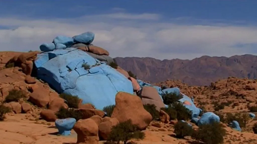 Weathered granite boulder at the Painted Rocks near Tafraoute with faded blue paint over pink granite texture