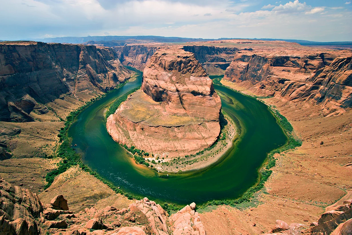 Horseshoe Bend from above with the Colorado River making a tight U-turn in the red Navajo Sandstone.